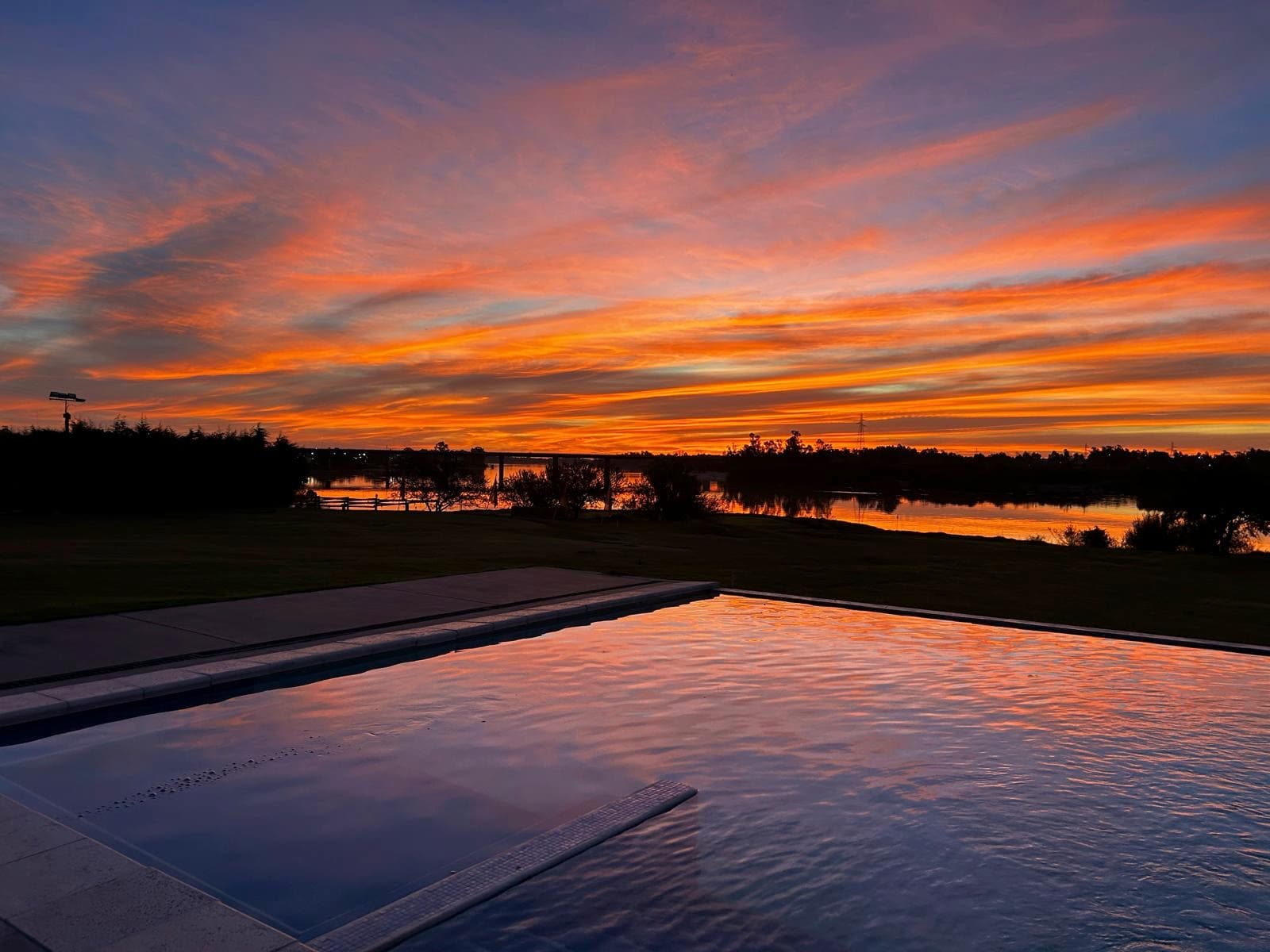 Club Hotel San Isidro — atardecer sobre la piscina y el Río Negro